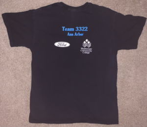 T-shirt laying flat - (Written in blue) Team 3322 - Ann Arbor Sponsor logos in white - Ford & WCC